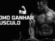 Homem musculoso treinando com barra, ilustrando dicas de como ganhar massa muscular com saúde